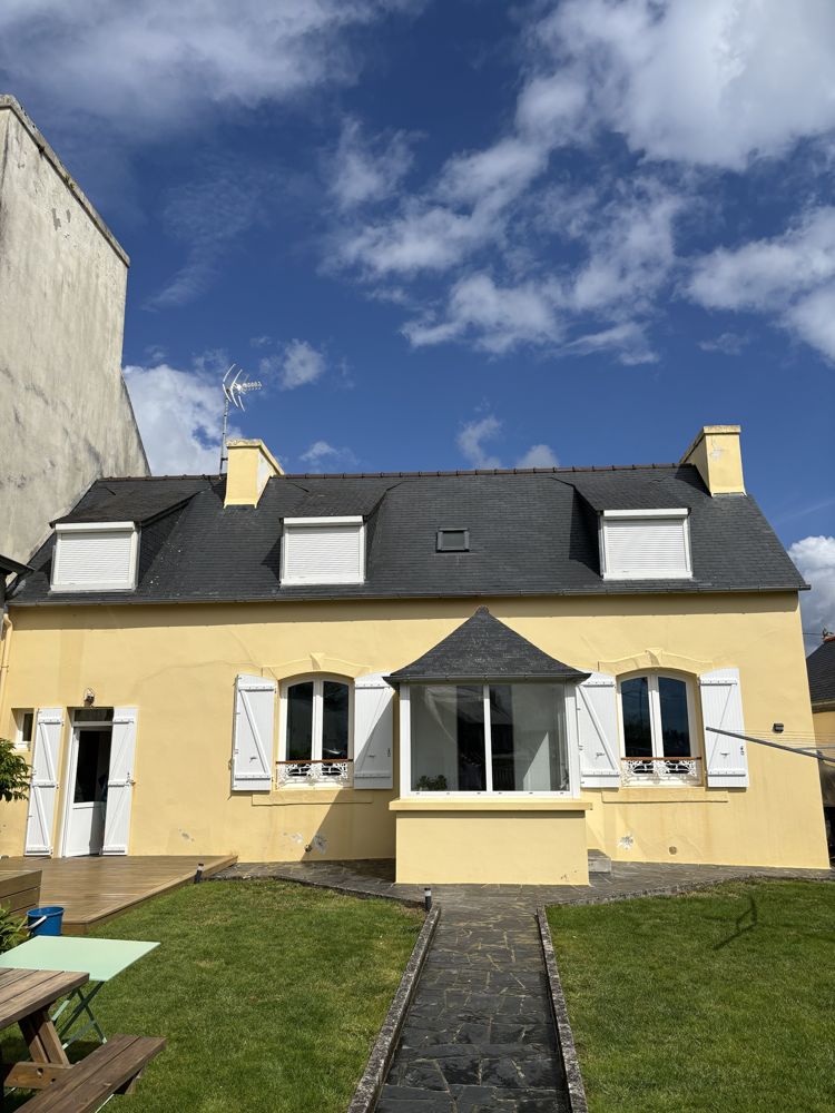 Façade jaune avant ravalement, avec fissures et enduit abîmé
